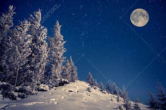 Full moon in the night sky in winter mountains