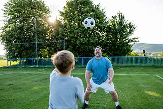 Dad and son sharing passion for football and active lifestyle.