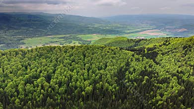 Aerial drone view of a crater lake shoreline with a forested rim and p