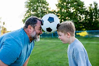 Dad and son sharing passion for football and active lifestyle.