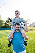 Dad and son sharing passion for football and active lifestyle.