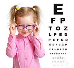 Smiling girl putting on glasses with blurry eye