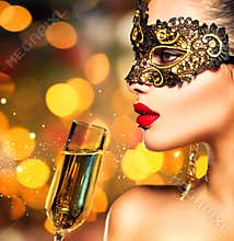 Woman wearing carnival mask with glass of champagne