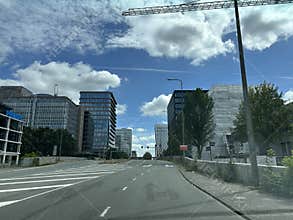 Modern office district street with tall glass buildings, road markings