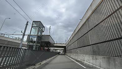 Modern urban transport corridor with concrete retaining walls, glass elevator