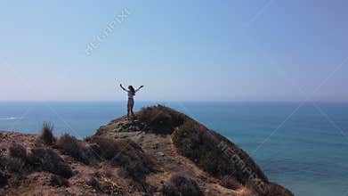 Woman on Cliff Edge Overlooking Ocean. Rocky Coast and Ocean