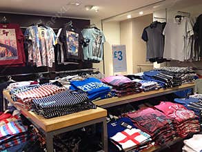Brightly colored T shirts folded in a store.