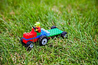 The toy lego tractor on green meadow