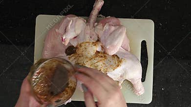 video of fresh chicken being marinated for baking in the oven.