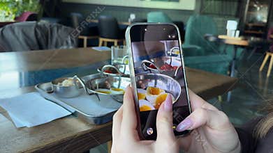 Food blogger filming breakfast closeup soft boiled eggs restaurant mobile phone shooting plating
