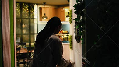 Casual african american woman walking around the house in cozy clothes