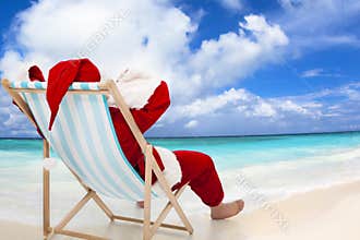 Santa Claus sitting on beach chairs. Christmas holiday concept.