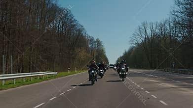 Steadicam shot of motorcycle convoy riding through a forest road