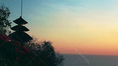 Traditional Balinese temple silhouette against a sunset sky
