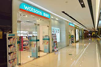 Modern retail shopping mall / centre with many busy shoppers shopping