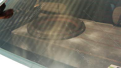 Subwoofer speaker system in custom enclosure installed in trunk of car, seen through rear window, emphasizing car audio upgrade