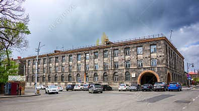 Historic-style building with parked cars and overcast sky