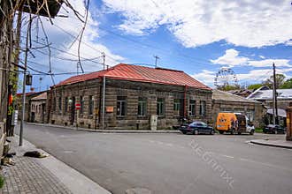 Historic urban scene with old building, street traffic, and clear sky