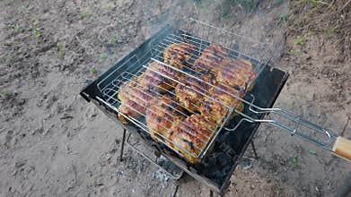 Juicy Marinated Chicken Thighs Grilling on a Charcoal Brazier Outdoors