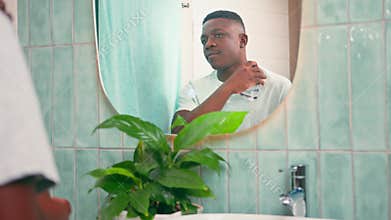 Confident Black Man Applying Cologne In Bathroom Mirror For Daily Grooming Routine