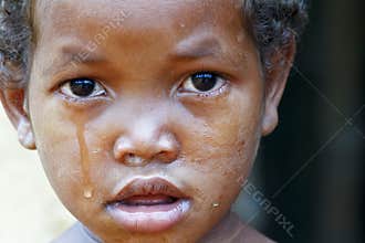 Crying girl with tear on cheek - poor african child