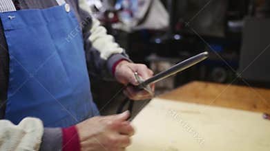 Old butcher sharpening his knife in slow motion