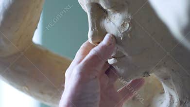 Scultor modeling woman sculpture in modeling clay