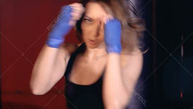 Beautiful active athletic woman boxing in fitness studio. Woman strength concept.