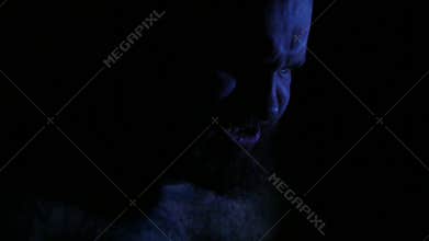 Man suffering and screaming in darkness. 4K UHD