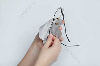 Women hand cleaning glasses lens with background.