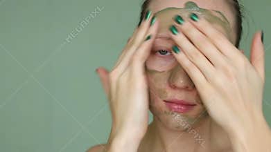 Woman doing cosmetic mask on her face