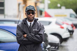 Male Security Guard Standing Arms Crossed On Street