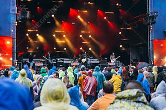 Crowd in raincoats during festival preformance