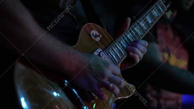 Actor guitarist playing the guitar. Musician plays a musical instrument on stage solo.