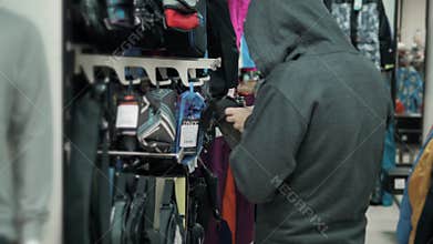 Thief in shop, shopping gangster, man hiding clothes at store