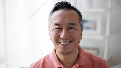 Face of happy smiling asian man at home