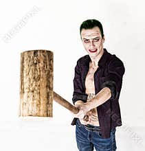Guy with crazy joker face, green hair and idiotic smile. carnaval costume. holding hammer for cricket