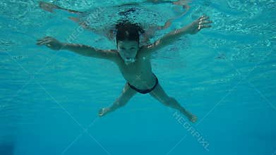 Boy swim in swimming pool, underwater slow motion