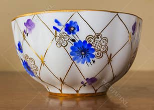 Porcelain sugar bowl, cup, milk, dish with golden pattern and blue flowers.