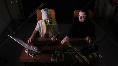 Male and female programmers making a hack. Top view shot.