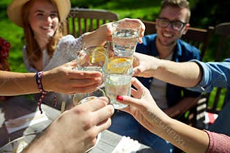 Happy friends with drinks at summer garden party