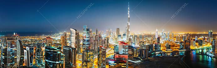 Aerial panoramic view of a big futuristic city by night. Business bay, Dubai, UAE.