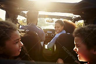 Happy family on a road trip in their car, rear passenger POV