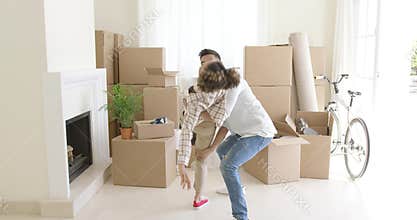 Mixed race couple dancing in new home