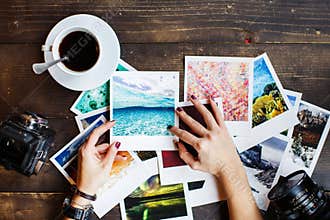 Top view of women`s hands holding printed photos
