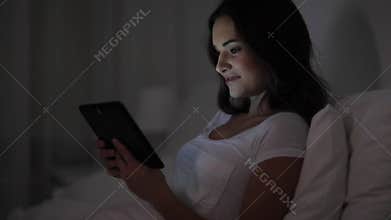Young woman with tablet pc in bed at home bedroom