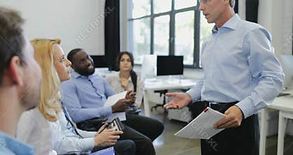 Group of business people listening to presentation ask question at seminar mature businessman leading training meeting