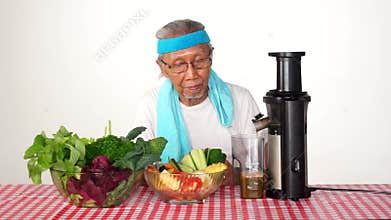 Old man makes vegetables juice