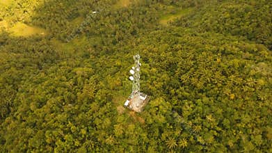 Telephone signal tower among green forest and mountains. Aerial view. Siargao island Philippines.