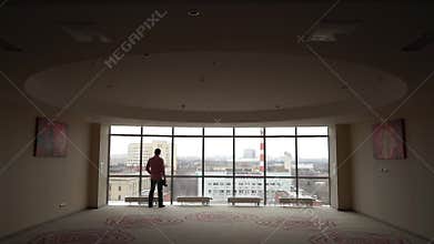 Photographer approaches the window, followed by an industrial landscape.